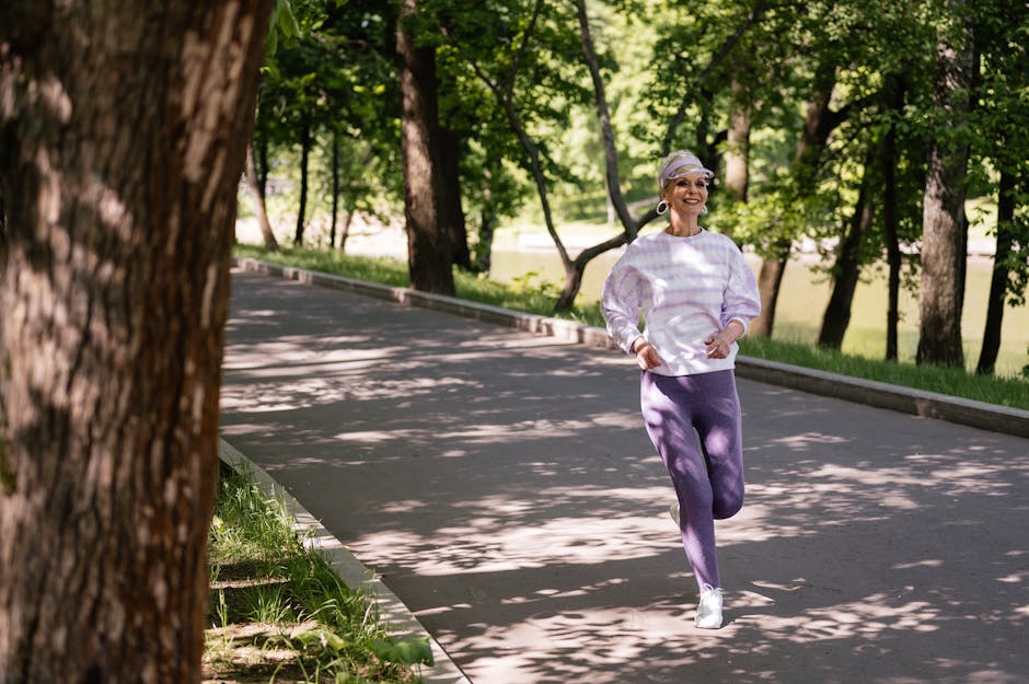 Elderly woman enjoying a refreshing jog in a lush green park during the day.