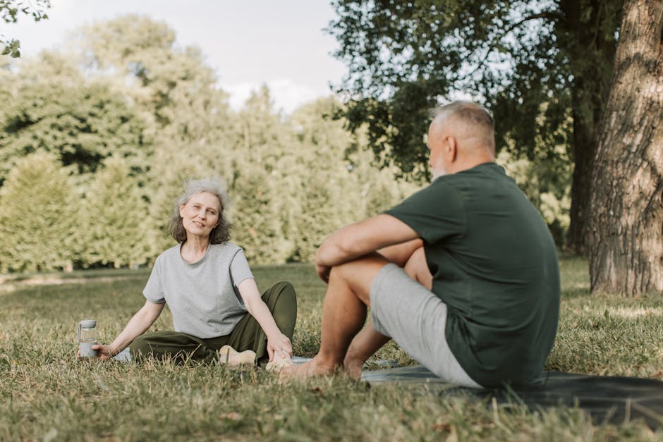 Senior couple practicing yoga and enjoying nature in a sunny park
