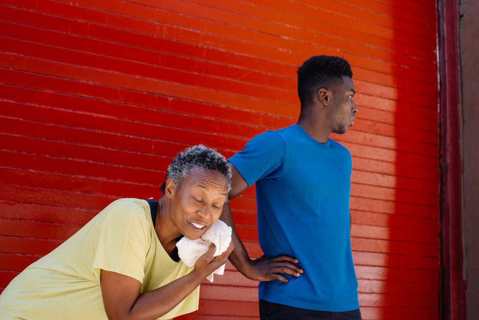 Two adults cooling down after exercise against a vibrant red wall, emphasizing an active lifestyle.